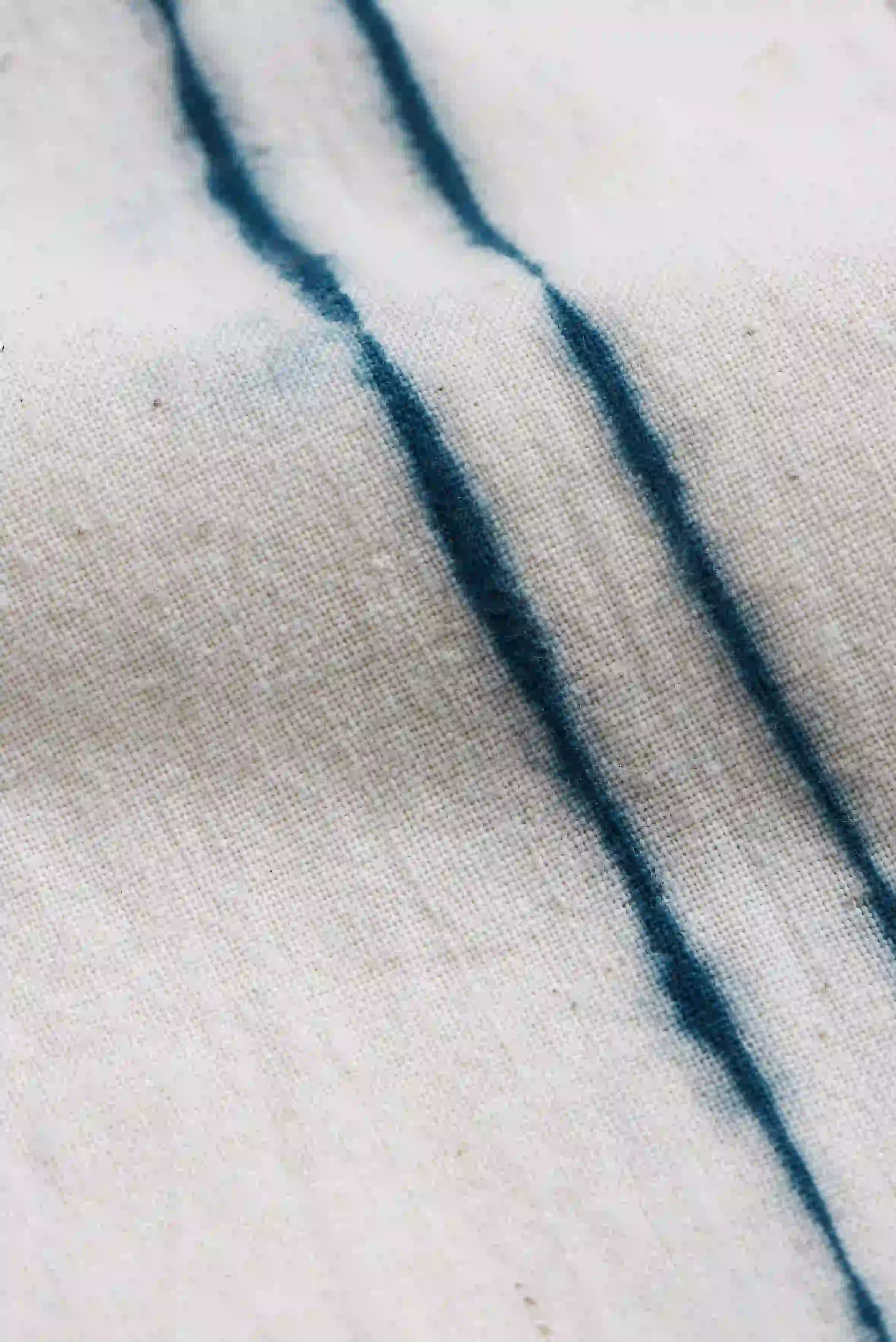Close-up of fabric with indigo stripes on a ecru fabric