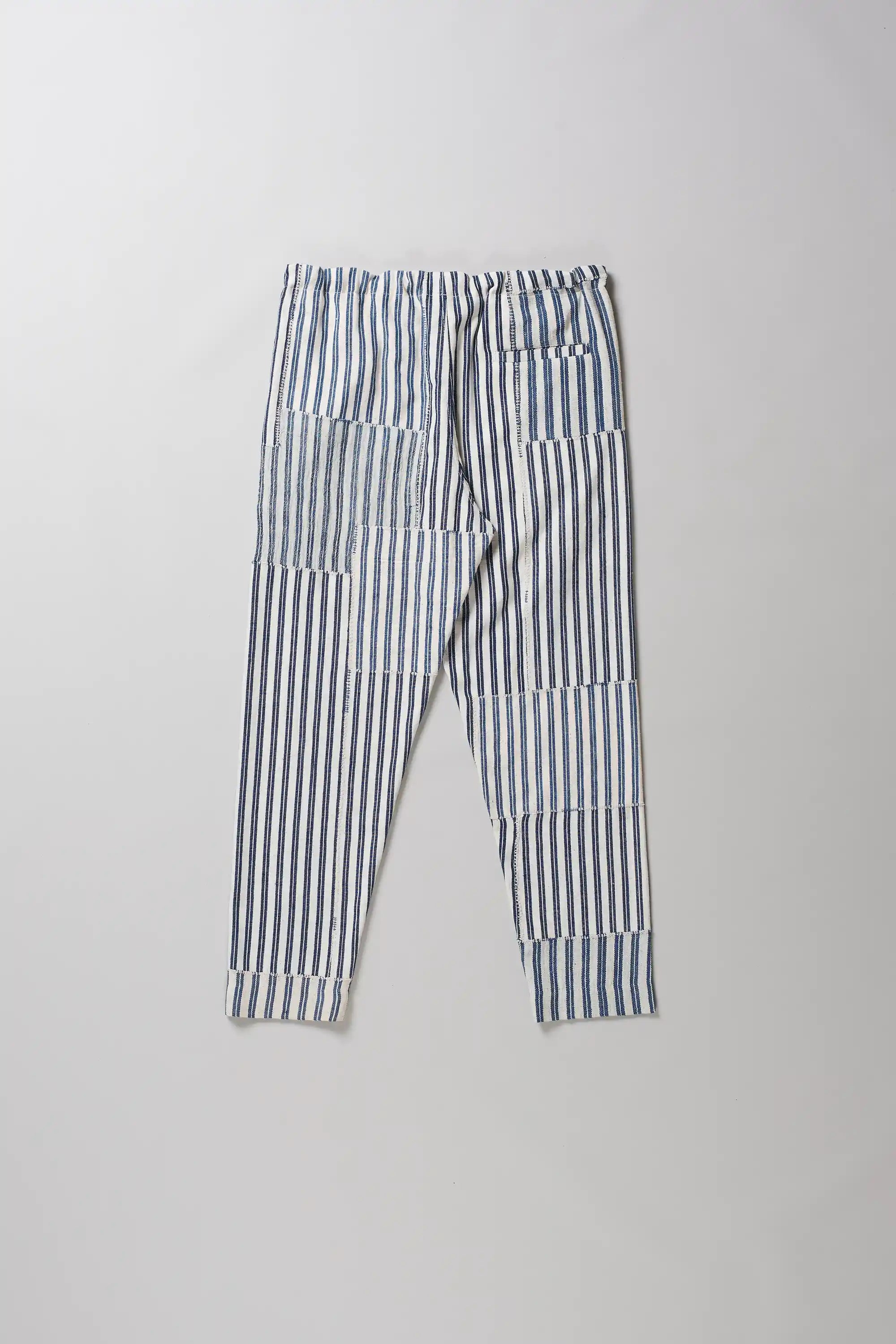 Back shot of pants with vertical blue and white stripes, laid flat on a light grey background.