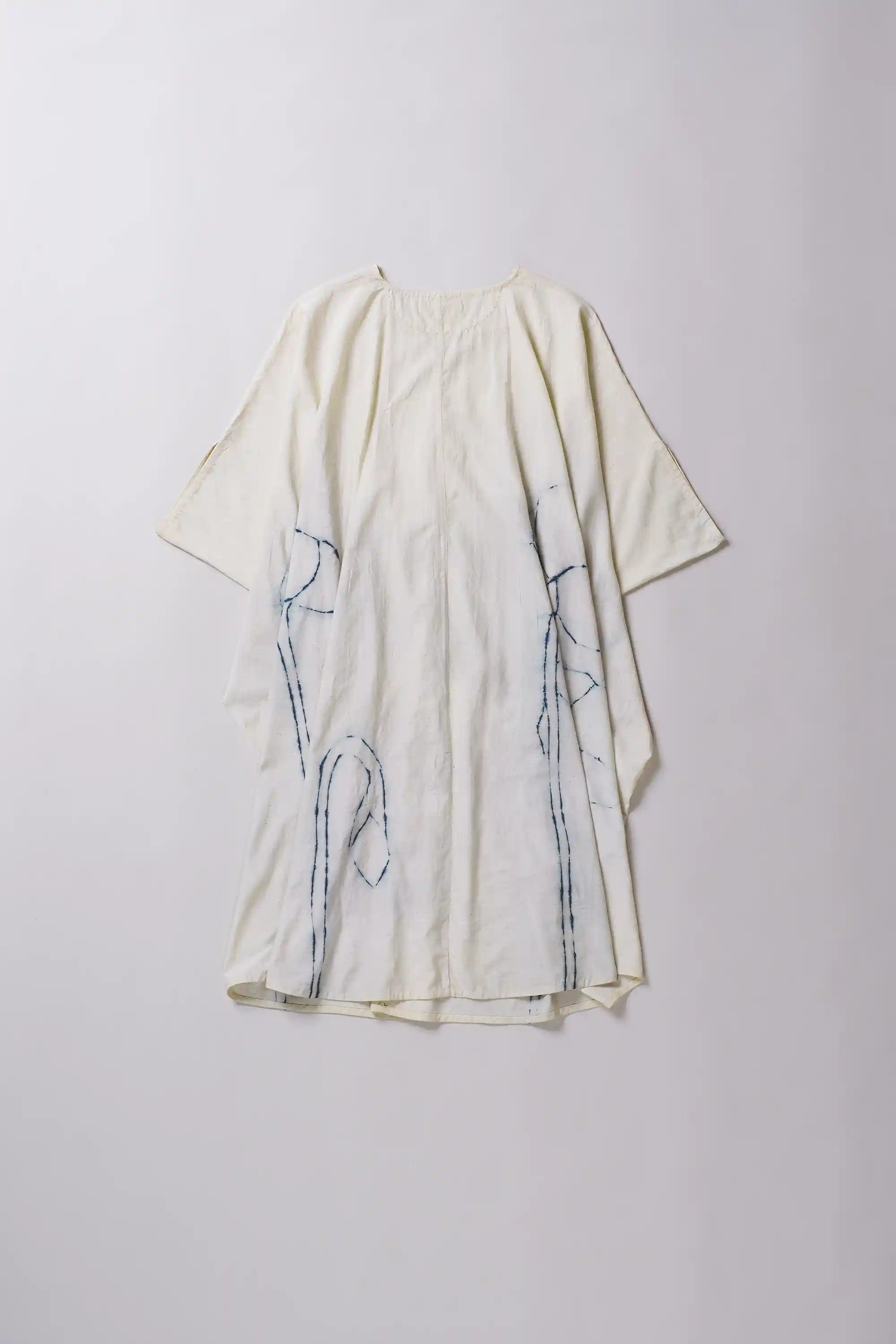 White dress with black abstract patterns on a light gray background