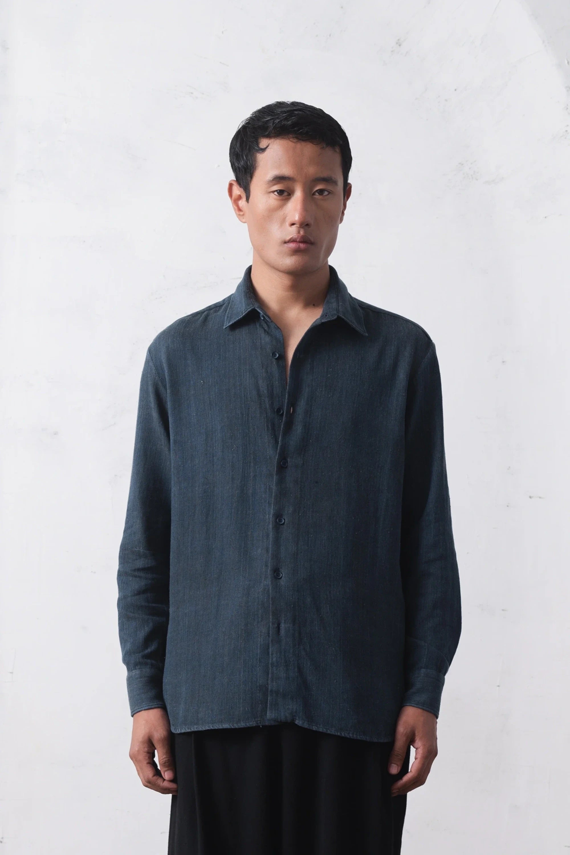Man wearing a indigo shirt on a light grey background