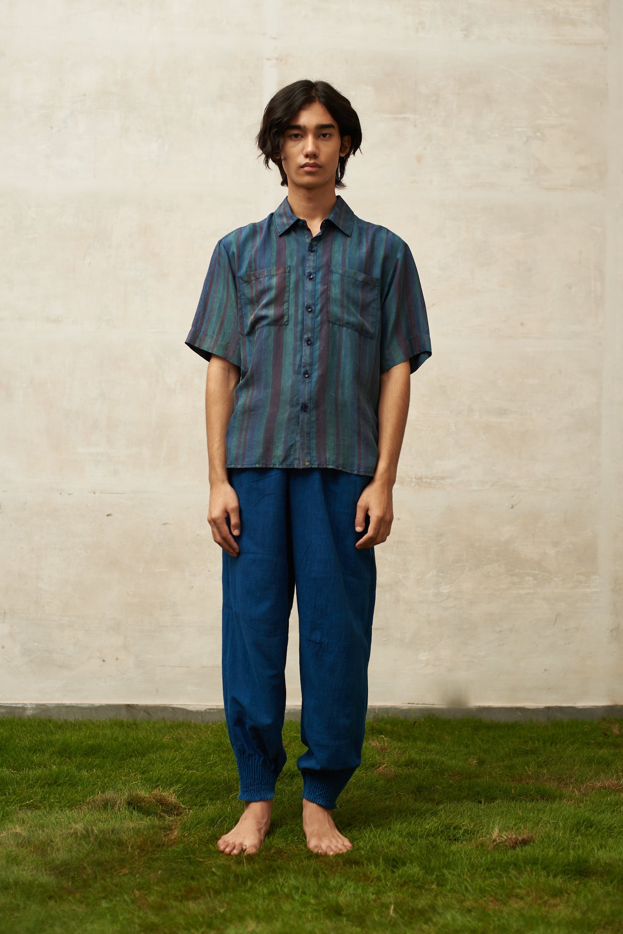 A man wearing medium indigo cotton pant with drawstring